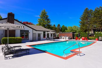 A pool with a red border and a metal ladder at Woodlake Apartments, Kirkland